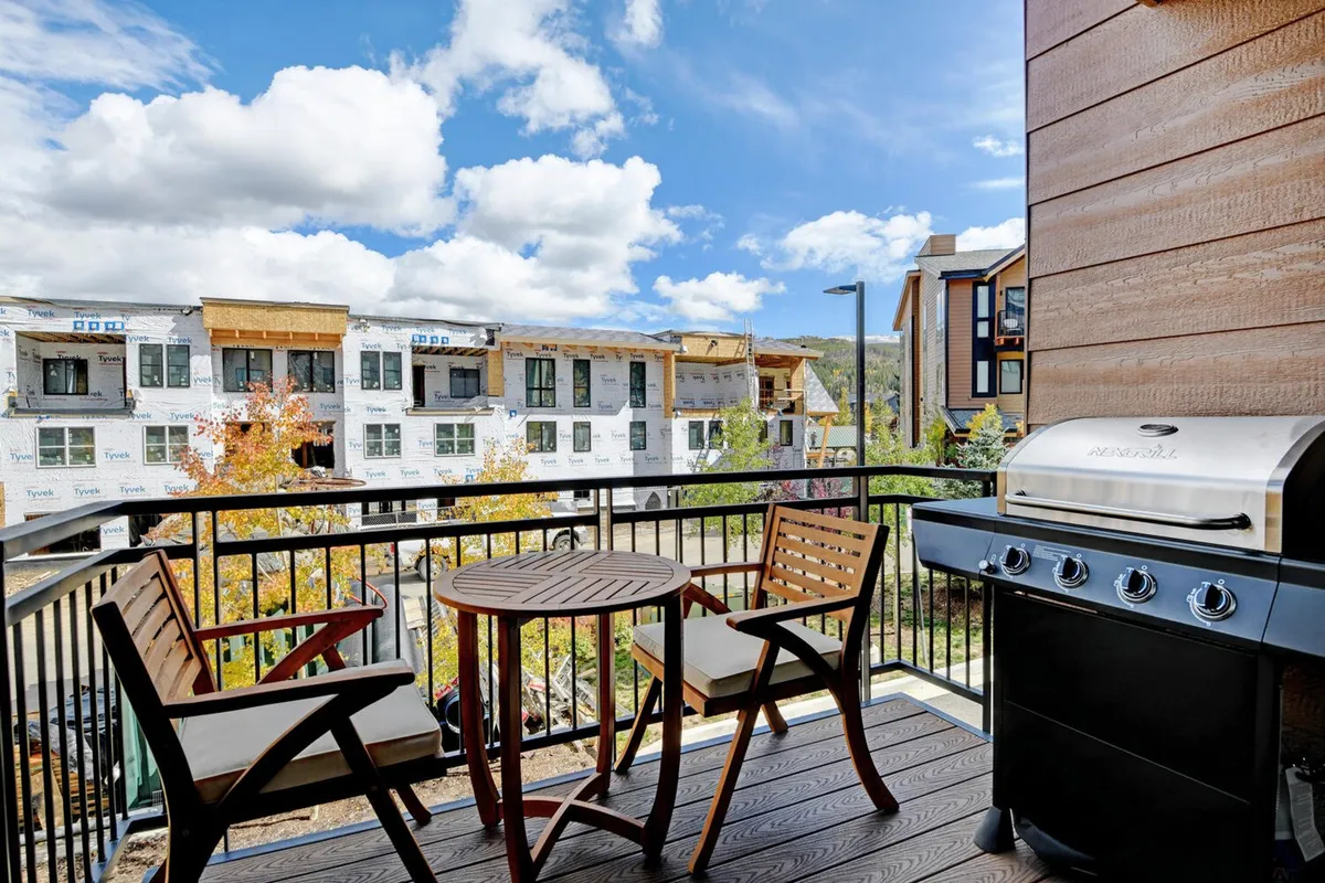 A rooftop or outdoor patio scene featuring comfortable seating, a barbecue grill, and expansive views. The outdoor space feels casual and sociable, ideal for relaxing or gathering with friends after an evening downtown.